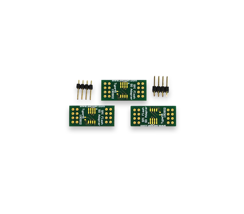 Three green circuit boards are displayed, each featuring multiple gold-plated pins and labeled as "ISP Adapter." There are also two sets of black connector pins positioned near the boards. The image highlights electronic components typically used for programming or connecting devices.